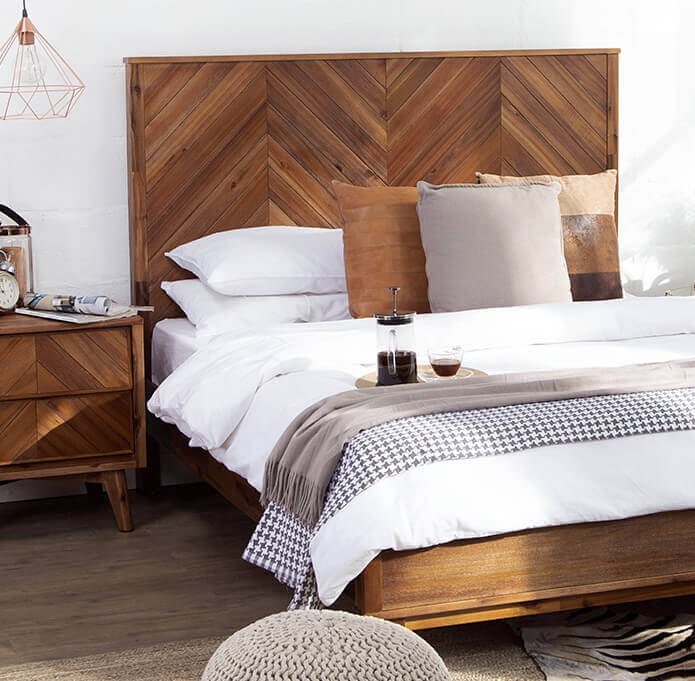 Acacia wood bed with white bedding and brown scatter cushions and matching acacia wood pedestal